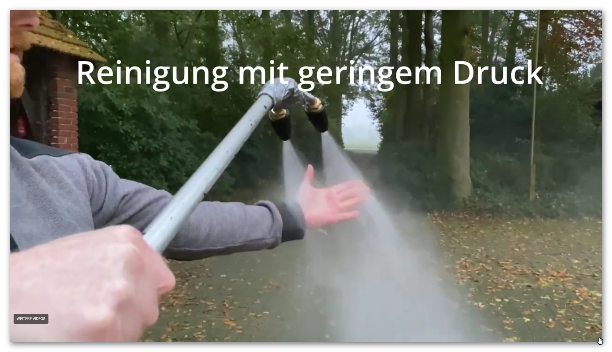 Demonstration der sanften Dachreinigung: Eine Hand h&auml;lt einen weichen Wasserstrahl, der materialschonend Verschmutzungen l&ouml;st.